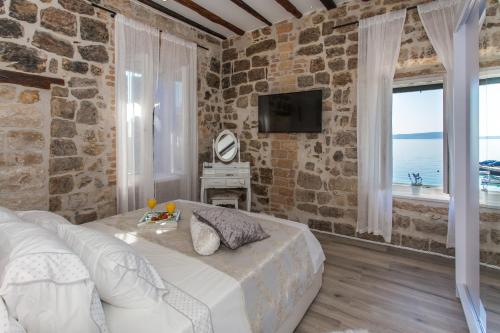 En eller flere senge i et værelse på Seafront apartment in historical Cippico castle