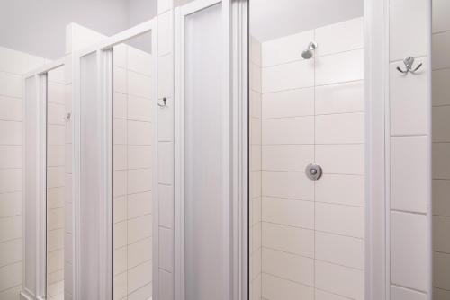 y baño con ducha de azulejos blancos. en Best Spot Hostel en Praga