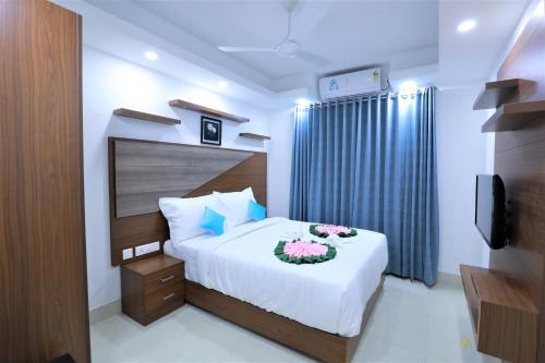 a bedroom with a bed with flowers on it at Swades Myhome in Trivandrum