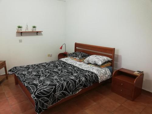 a bed with a black and white comforter in a bedroom at Chriselina Gottage in Paphos