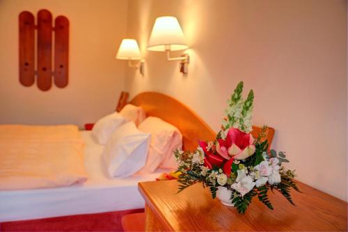 una camera d'albergo con un tavolo con una composizione floreale di Park Hotel Pruhonice a Pruhonice