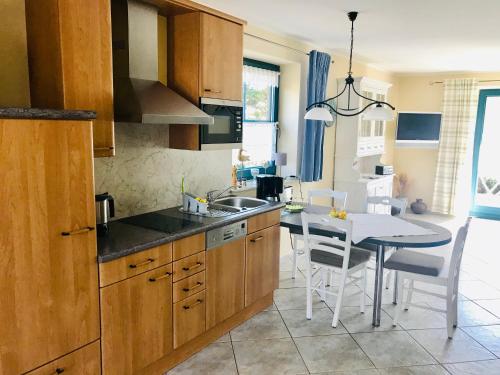 a kitchen with a sink and a table with chairs at "Backbord" by Ferienhaus Strandgut in Born