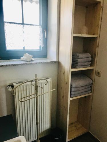 a bathroom with a radiator and a window and towels at "Backbord" by Ferienhaus Strandgut in Born