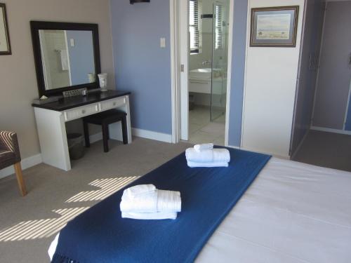 a hotel room with a bed with towels on it at An Der Mole Apartment in Swakopmund