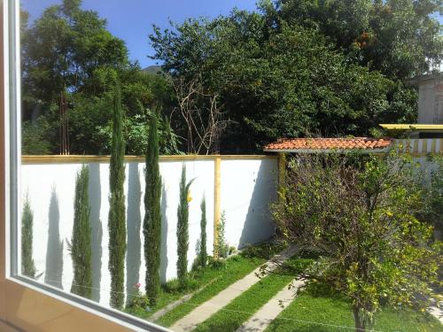 a garden with trees and a white fence at Casa Elim-Oaxaca in Teotitlán del Valle