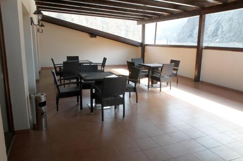 a dining room with tables and chairs and windows at Hotel Class in Brezoi