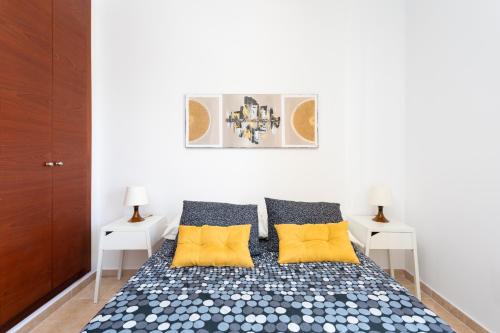 a bedroom with a bed with yellow pillows at Home2Book Beautiful Duplex Arona in Arona