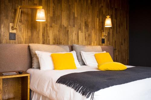 a bedroom with a bed with two yellow pillows at Casa de Uco Vineyards and Wine Resort in Los Árboles