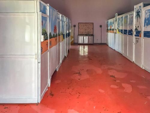 an empty hallway with a red floor in a building at Il Triangolo Hostel in Las Galeras