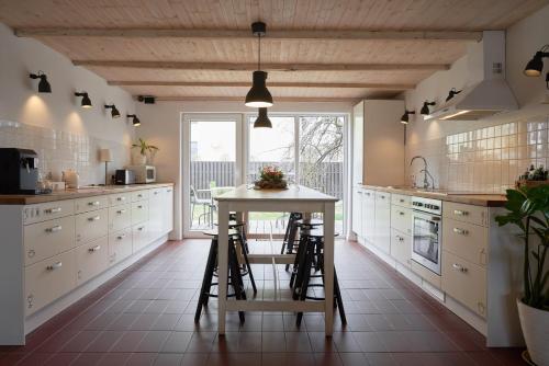 a kitchen with a table and stools in it at SAKÀ Vacation House in Druskininkai