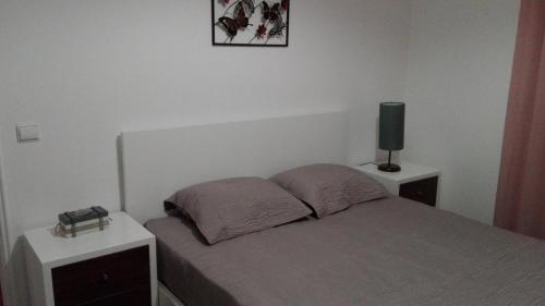 ナザレにあるApartamento Nazaréのベッドルーム1室(ベッド1台、ナイトスタンド2台、テレビ付)