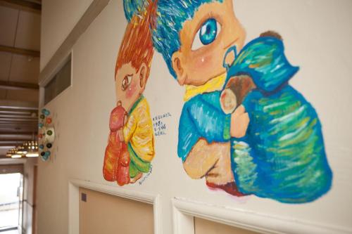a large painting on the wall of a room at May Rooms Taipei Nangang Station in Taipei
