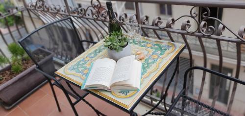 a table with a book and a potted plant on it at Ines bed and breakfast in Giardini Naxos