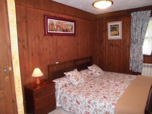 a bedroom with a bed in a room with wooden walls at El Molino in Arenas de Cabrales