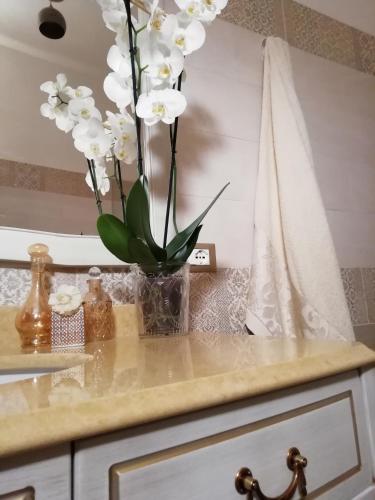 a vase with white flowers sitting on top of a counter at B&B Libertà Marsala in Marsala