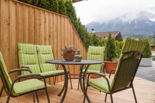 a patio with four chairs and a table on a deck at Appartement Hoschek in Scheffau am Wilden Kaiser