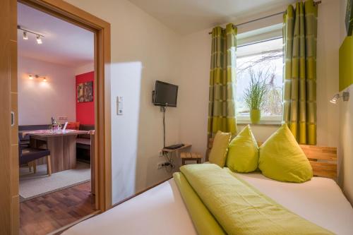 Appartement Hoschek في شيفو أم فيلدن كايزر: غرفة نوم بسرير مع مخدات صفراء