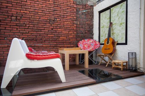 um pátio com uma guitarra, uma cadeira e uma guitarra em May Rooms Taipei Nangang Station em Taipei