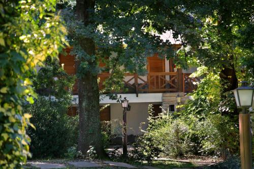 a building behind some trees and a street light at Posada del Sauce in Villa General Belgrano