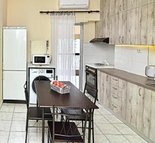 una cocina con mesa y algunas sillas. en City Center / Apartment 70 sqm / With View (Location Kamara) en Tesalónica