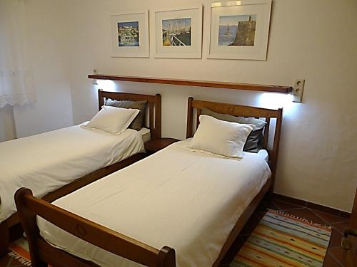- 2 lits dans une chambre avec des draps blancs dans l'établissement Casa São João, à Peniche