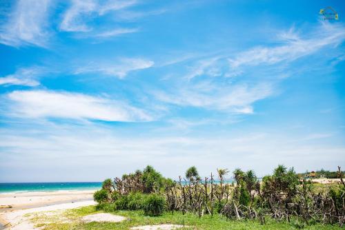 a beach with a blue sky and the ocean at Hoàng Ngọc's House in Tuy Hoa
