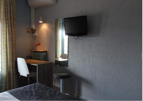 um quarto de hotel com uma televisão na parede em Europa Hotel em Roussillon en Isere