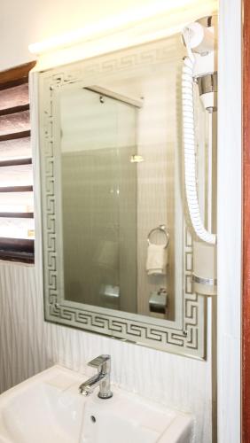 a bathroom with a sink and a mirror at Vivid Colombo in Colombo