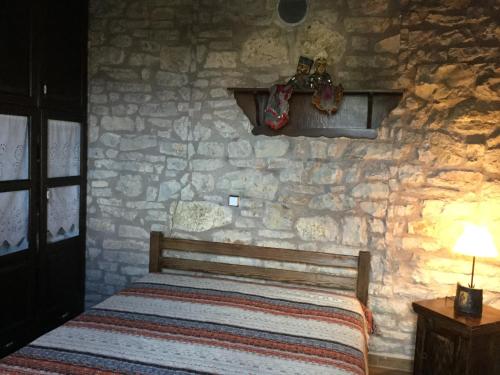 克利托里亞的住宿－Filia House - Kalavryta，卧室配有一张石墙床
