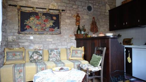 a living room with a couch and a table and a painting at Filia House - Kalavryta in Klitoria