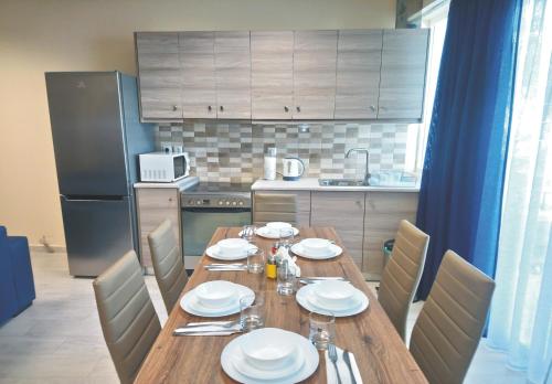 a kitchen with a wooden table with plates on it at JK's GUESTHOUSE KARDAMAINA in Kardamaina
