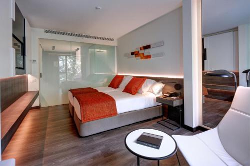 
a hotel room with a bed, table and a lamp at Olivia Balmes Hotel in Barcelona
