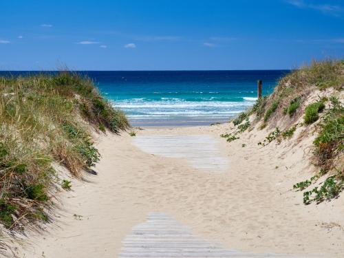 a sandy path leading to the ocean on a beach at Hotel Samar in A Lanzada