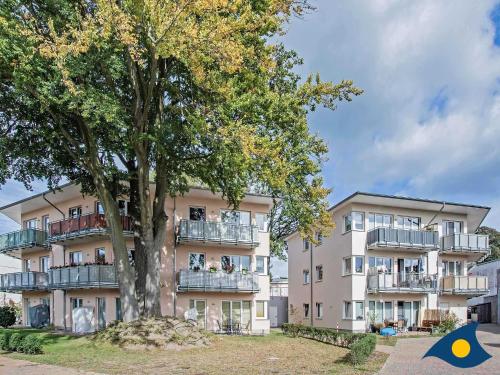 un edificio de apartamentos con un árbol delante de él en Villa Hügel B 02 "Zaczernie", en Ahlbeck