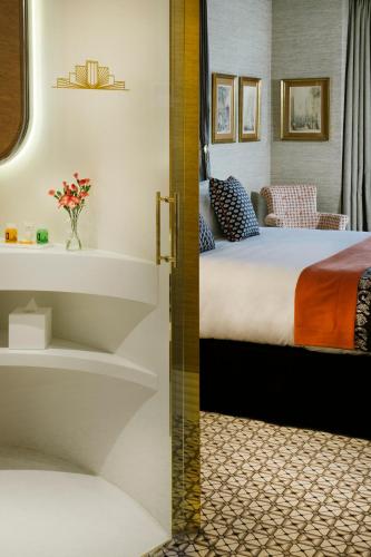 a hotel room with a bed and a bathroom at The First One Madrid Preciados in Madrid