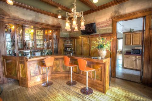 a kitchen with a bar with orange chairs at Lauerman House Inn Bed & Breakfast in Marinette