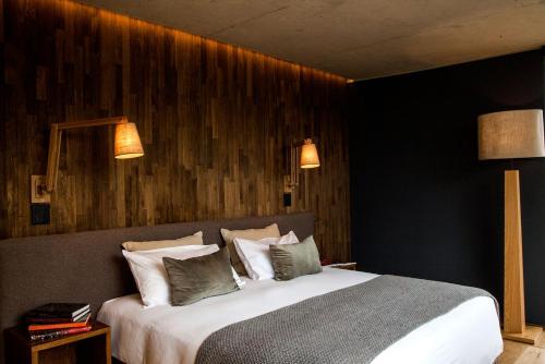 a bedroom with a large bed and two lights at Casa de Uco Vineyards and Wine Resort in Los Árboles
