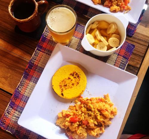 a table with a plate of food and a drink at Nibiru Hostel in Villa de Leyva