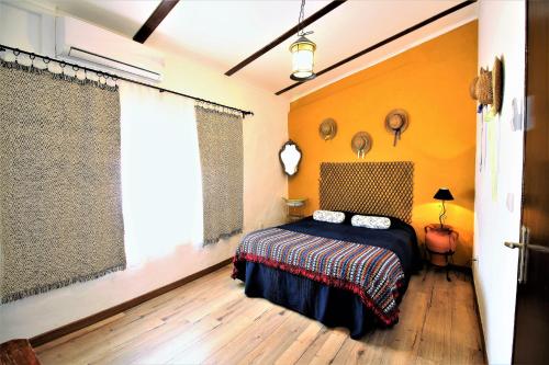 a bedroom with yellow walls and a bed and a window at Casa da Beata in Elvas