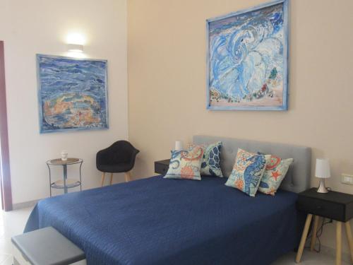 Un dormitorio con una cama azul y una pintura en la pared en Polpo e Polpessa Casa Vacanze, en Lipari