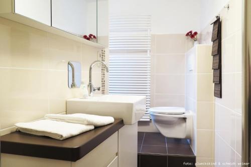 ein weißes Bad mit einem Waschbecken und einem WC in der Unterkunft Ferienwohnung "Oha" in Bad Berka