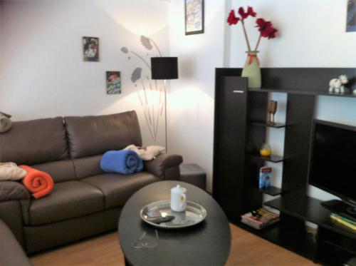 a living room with a couch and a table at Spacieux Appartement au coin de la plage in Middelkerke