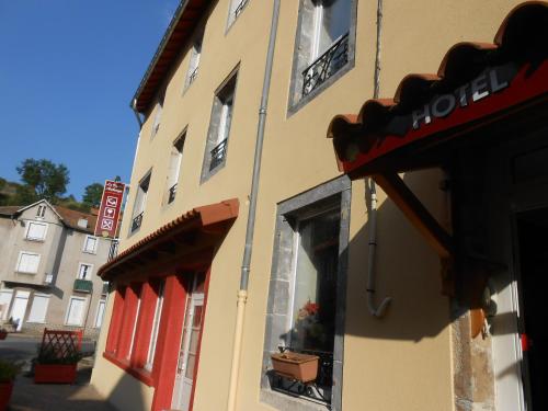 a building with red doors and windows on a street at La Vieille Auberge in Saint-Privat-dʼAllier
