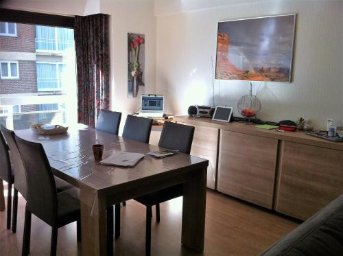 une salle à manger avec une table et des chaises ainsi qu'une cuisine dans l'établissement Spacieux Appartement au coin de la plage, à Middelkerke
