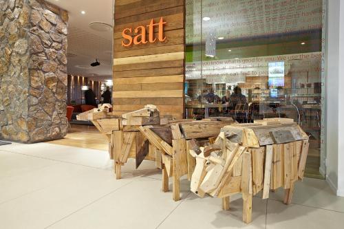 a restaurant with wooden tables and chairs in a store at Reykjavik Natura - Berjaya Iceland Hotels in Reykjavík