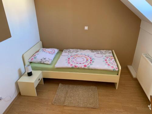 a small bedroom with a bed and a rug at Vinarija Zlatar in Zlatar