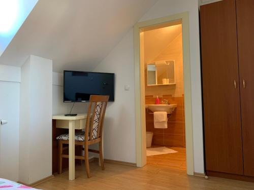 a room with a desk with a television and a bathroom at Vinarija Zlatar in Zlatar