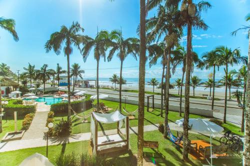 a view of the pool and beach from the balcony of a resort at Hotel VillaReal Guaratuba - Caieiras in Guaratuba
