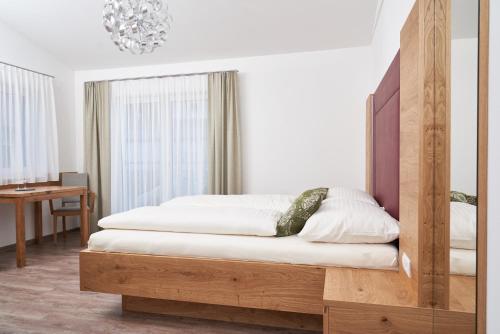 a bedroom with a bed with a wooden headboard at Weinhof - Gästehaus Maier in Angern