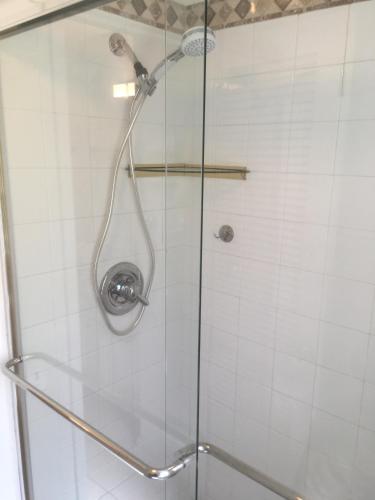 a shower with a glass door with a shower head at Beach Townhouse in St Thomas